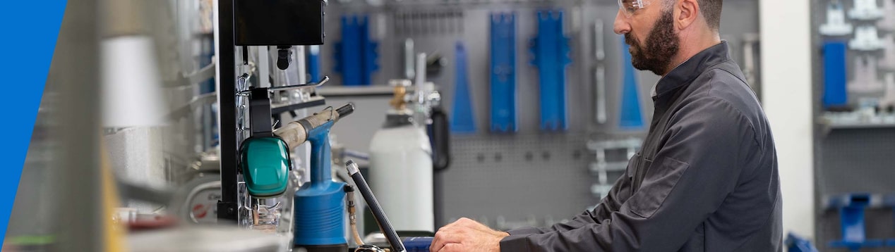 Technician Standing at a Work Station Typing on a Computer