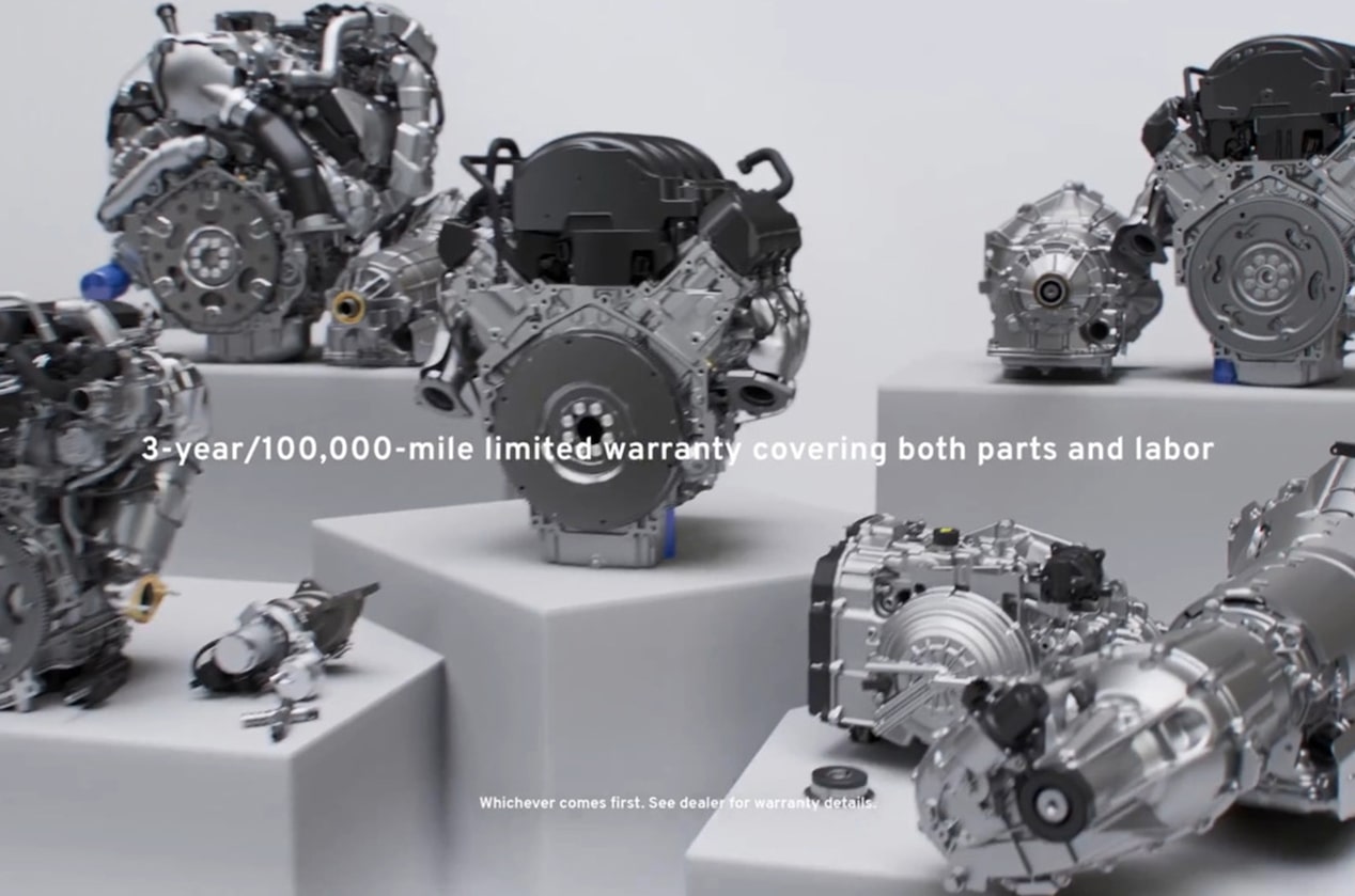 Various GM Genuine Engines Sitting on Display with Text Overlay "3-year/100,000-mile limited warranty covering both parts and labor"